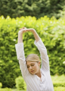 Young woman with arms stretched and eyes closed
