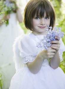 Portrait of a young girl in a fairy costume holding flowers