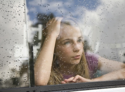 Portrait of a young girl looking out of a car window
