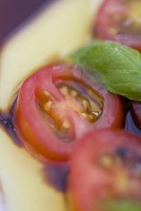 Cherry tomatoes and basil leaves in olive oil and balsamic vinegar dressing