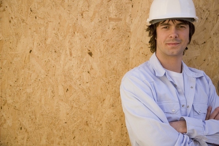 Portrait of a young man wearing hard hat at construction site