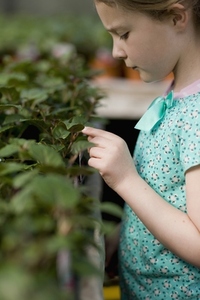 Young girl touching a plant in a nursery