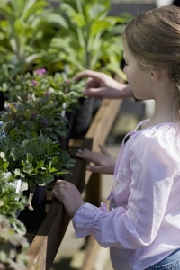 Young girl in a nursery looking at plants