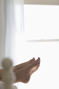 Woman feet overhanging from end of bed