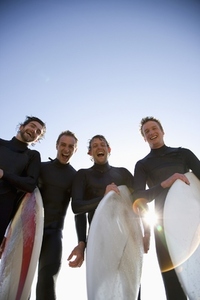 Surfers holding surfboards laughing and screaming