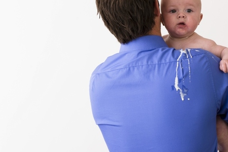 Back view of a man holding a baby with vomit on his back and shoulder