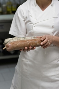 Woman chef holding salami