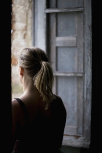 Back view of a woman looking out of a window
