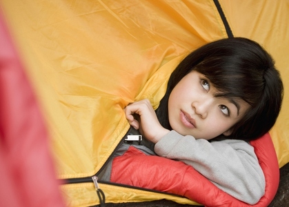 Close up of  teenaged girl head coming out of tent entrance