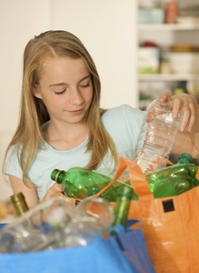 Young girl recycling plastic bottles