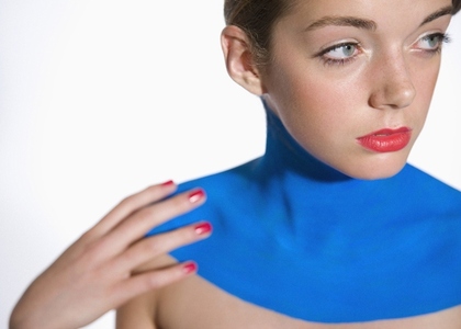 Beautiful young woman with decollete painted with electric blue body paint