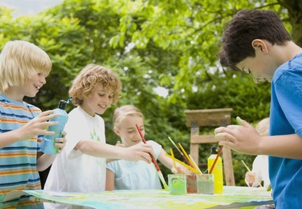 Children painting and smiling in Garden
