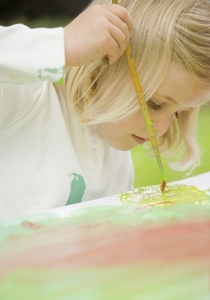 Close up of a young blonde girl painting