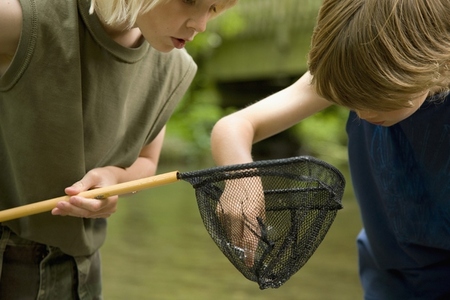 Two young boys inspecting  the content of a fishing net