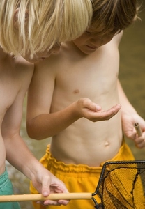 Two young boys inspecting the content of a fishing net