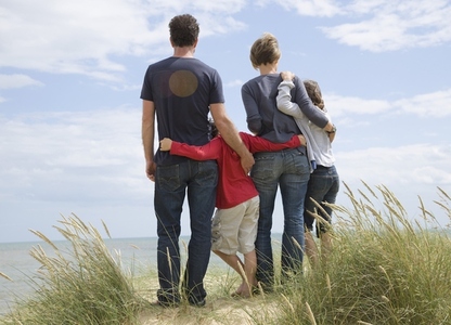 Back view of a family standing on a beach