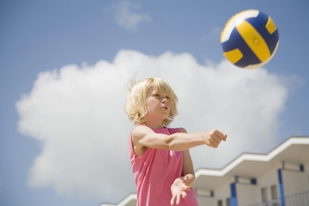 Blonde boy playing volleyball