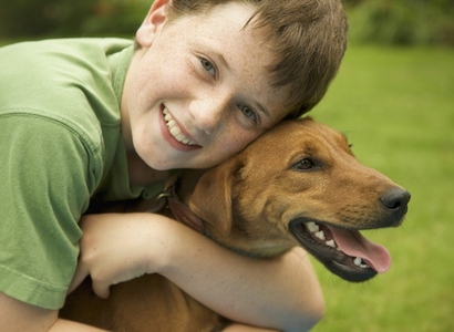 Young smiling boy embracing his dog