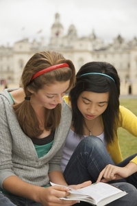 Two teenaged girl reading a book in front of  London Horse Guards Parade