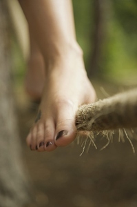 Close up of a woman feet walking on tightrope