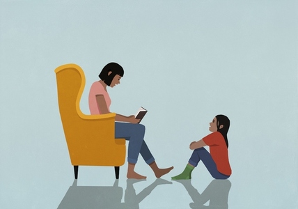 Mother in armchair reading book to daughter at home