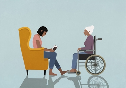 Woman in armchair reading book to senior woman in wheelchair