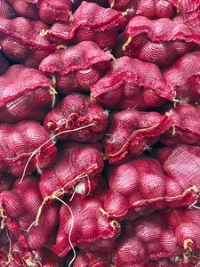 View from above bunches of onions in red sacks