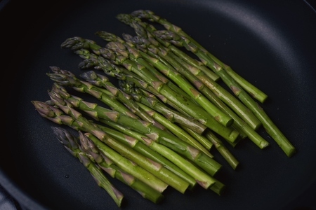 Vibrant green asparagus cooking in pan