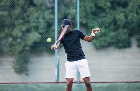 Professional tennis player hitting the ball outdoors