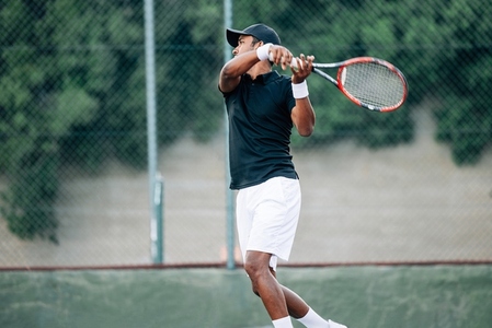 Side view of a professional tennis player returning the serve