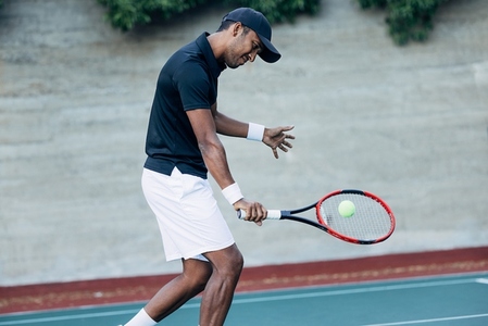 Young man playing tennis outdoors  Tennis player hitting a ball