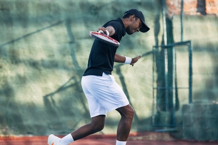 Tennis player doing intense training outdoors