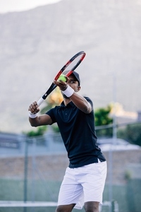 Tennis player preparing to serve outdoors