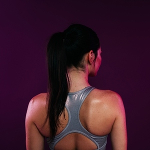 Rear view of a slim muscular woman in a silver bra