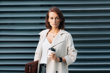 Confident businesswoman with ginger hair  Middle aged business person wearing stylish clothes holding a leather folder