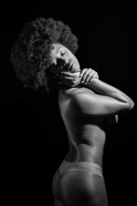 Black and white photograph of naked African American model under studio illumination