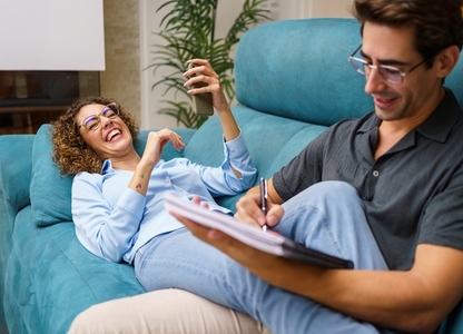 Happy couple spending time together over couch in living room