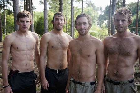 Young men standing in a forest shirtless and wet