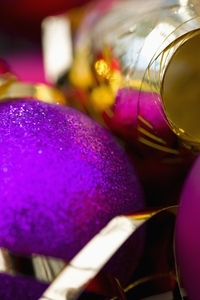 Extreme close up of a purple Christmas bauble and a gold ribbon