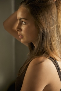 Profile of a young woman pulling hair back