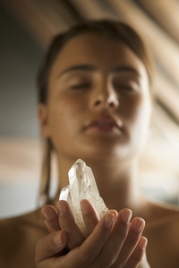 Young woman holding crystal in her hands