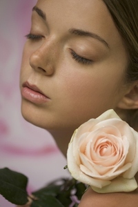 Close up of a young woman with a rose on her shoulder