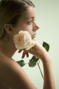 Profile of a young woman holding a rose