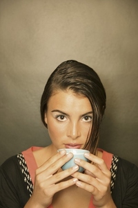 Young woman holding a cup of green tea