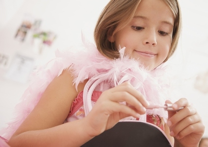 Girl wearing a pink feather boa holding a lip gloss