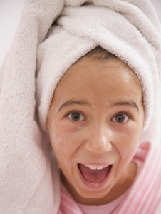 Close up of a girl with face mask on wearing a towel turban screaming and smiling