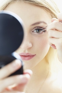 Close up of Young Woman Applying False Eyelashes