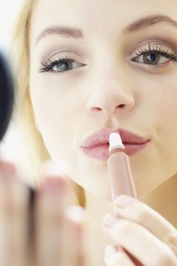 Close up of Young Woman Applying Lip Gloss