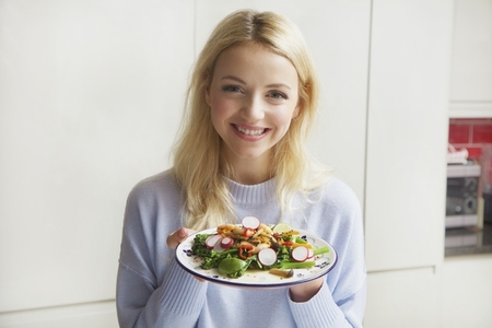 Smiling Woman Holding Plate with Stir Fry