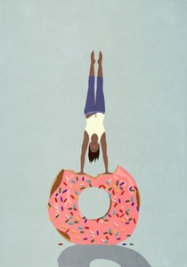 Woman doing handstand on donut with missing bite